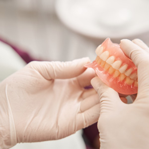 Dentist holding full dentures
