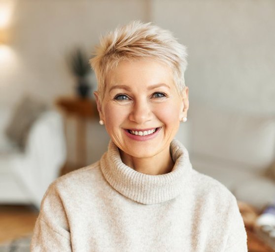 a woman smiling while relaxing at home