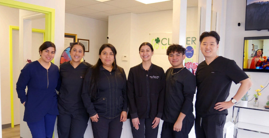 The dental team at Clover Dental Care poses together, showcasing their commitment to patient care by the sea.