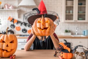 Woman holding a jack-o'-lantern above her head